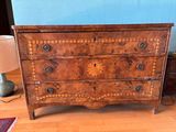 a small chest of drawers in the corner of a room
