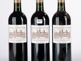 trois bouteilles de vin posées les unes à côté des autres sur une surface blanche
