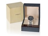 une photo d'une montre noire et argentée dans un coffret