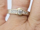 a woman ' s hand holding a ring with a diamond on it