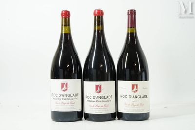 trois bouteilles de vin rouge sont alignées sur une surface blanche