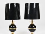 a pair of black and gold table lamps with black shades