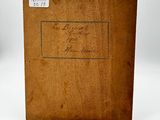 an old book with writing on it sitting on a white surface