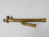 a brass plated telescope on a white surface