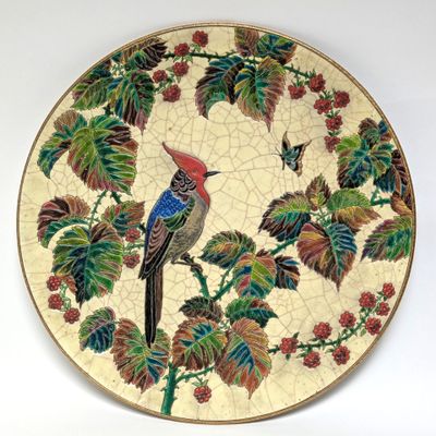 a decorative plate with a bird on a branch of a tree