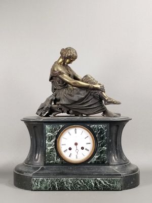 une statue de femme assise au sommet d'une horloge