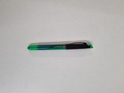 a close up of a green pen on a white surface