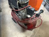 a small air compressor sitting on the floor in a room