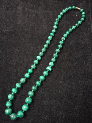 un collier de perles vertes sur fond noir