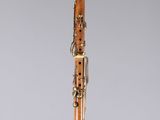 a close up of a wooden clarinet on a clear surface