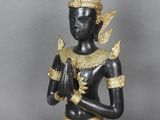 une image représentant une statue noire et dorée posée sur une surface grise