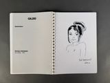 a drawing of a woman ' s face in a notebook
