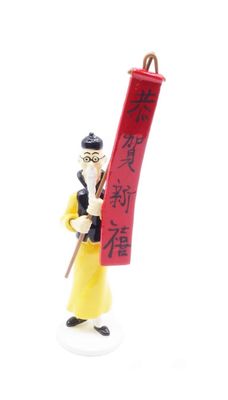 figurine of a man holding a red scroll with chinese writing