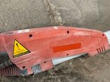 an image of a red and white corded drill on the ground
