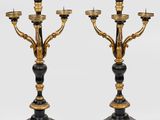 une paire de chandeliers noirs et dorés avec des bougies