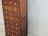 a tall wooden chest of drawers in a room