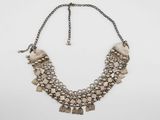the necklace is made of metal and has a chain with beads on it