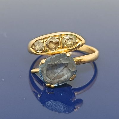 paire de bagues en or ornées d'une pierre bleue et de diamants sur un fond bleu