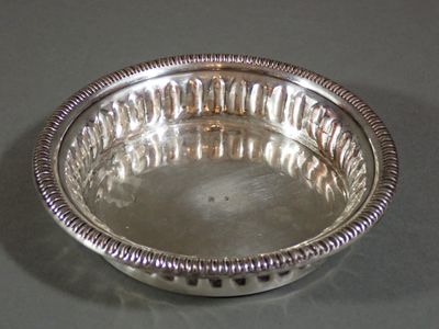 Dessous de bouteille en métal argenté à décor godronné.