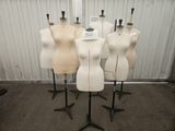 Quatre mannequins sont alignés sur des socles dans une pièce