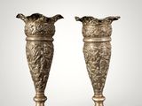 a pair of antique brass vases on a white background