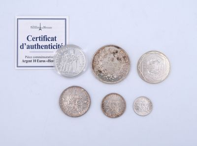 some coins are sitting on a white surface next to a certificate