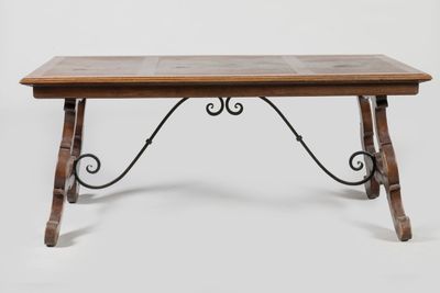 an old wooden table with iron legs and a tile top
