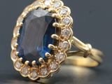 un gros plan d'une bague en saphir bleu et diamants