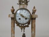 une horloge posée sur un socle en marbre
