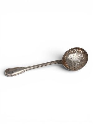 silver spoon on a white surface with a spoon in the middle