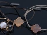 two bracelets with pink and white beads on a black surface