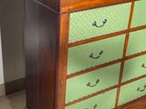 a wooden dresser with green drawers in a room