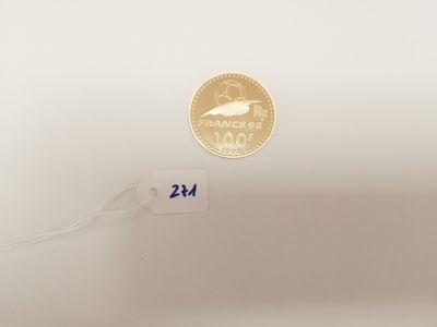a gold coin on a white surface next to a string