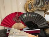 a red and black fan sitting on a table next to a mirror
