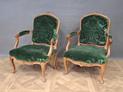 paire de fauteuils en velours vert avec des accoudoirs en bois sculpté