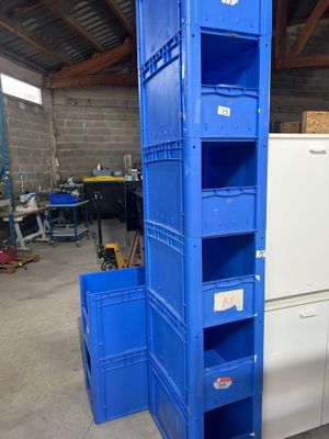 une pile de caisses bleues dans un entrepôt équipé d'un réfrigérateur