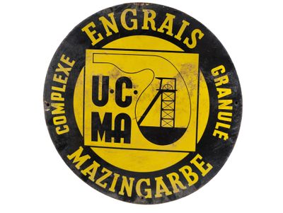 l'image d'un bouton jaune et noir portant les lettres « u c m a » et l'image d'une grue