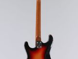 an electric guitar hanging from a string on a white background