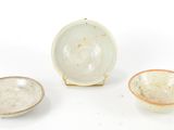 three small bowls and a small bowl are sitting on a white surface