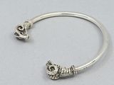 a close up of a silver bracelet with a cat on it