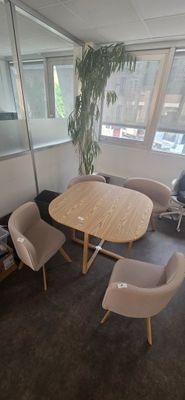 une table et des chaises dans une pièce dotée de grandes fenêtres