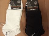 deux paires de chaussettes de tennis noires et blanches posées sur une boîte en carton