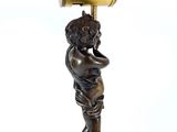 a bronze statue of a boy holding a barrel