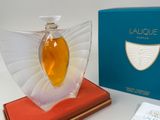 a bottle of perfume sitting on top of a red book