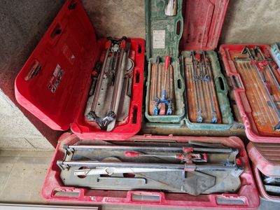 beaucoup d'outils dans une mallette rouge posée par terre