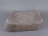 an old stone bowl sitting on top of a gray surface