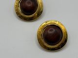 une paire de boucles d'oreilles avec des boutons en or et en bois