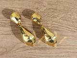 pair of gold plated earrings on a wooden surface