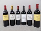 six bottles of red wine are lined up on a table
