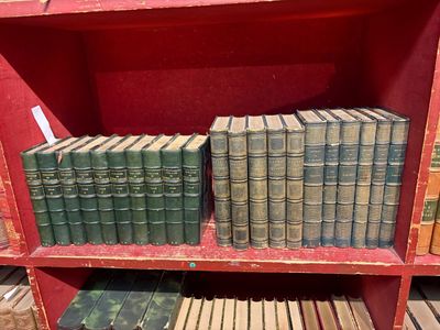 de nombreux livres anciens posés sur une étagère rouge dans une bibliothèque